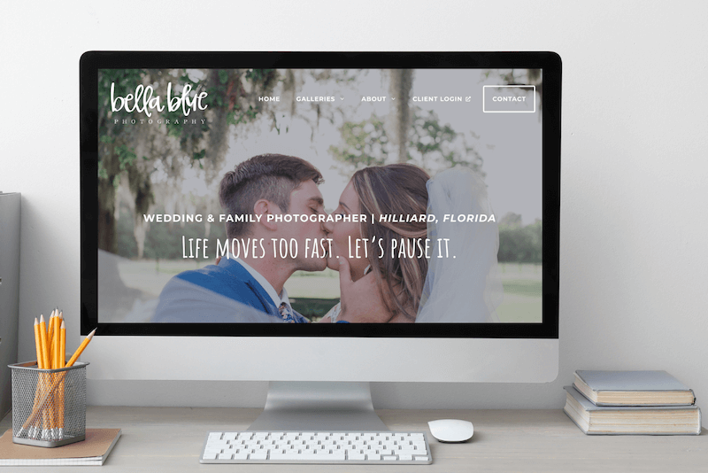 A mockup with a large Mac desktop showing Bella Blue Photography's website home page of a married couple kissing